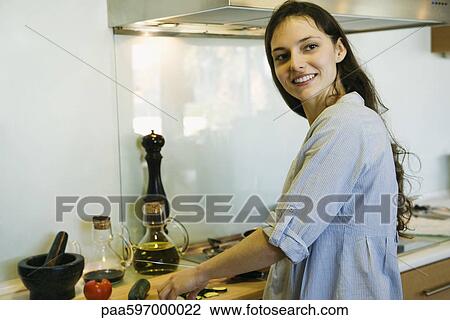 Woman cooking, smiling over shoulder, portrait View Large Photo Image Stock Image - Woman cooking, smiling over shoulder, portrait. Fotosearch