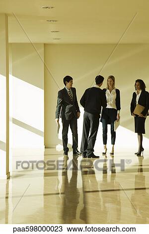 Business associates talking together in lobby View Large Photo Image Stock Image - Business associates talking together in lobby. Fotosearch