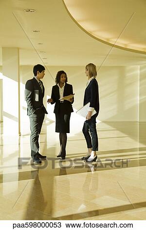 Business executives standing together talking View Large Photo Image Stock Image - Business executives standing together talking. Fotosearch