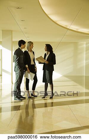 Business executives standing together talking View Large Photo Image Stock Photograph - Business executives standing together talking. Fotosearch