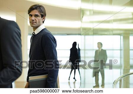 Stock Photo - Businessman in lobby, portrait. Fotosearch