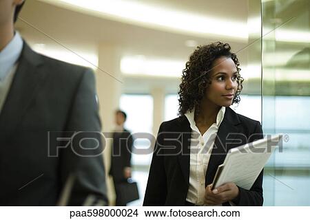 Picture - Businesswoman looking out window, portrait. Fotosearch