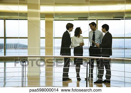 Picture - Group of executives talking in corridor. Fotosearch