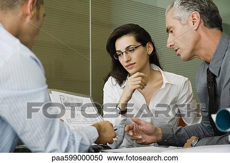 Business people discussing blueprint View Large Photo Image Stock Image - Business people discussing blueprint. Fotosearch