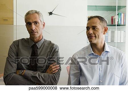 Businessmen standing side by side in office, portrait View Large Photo Image Stock Photo - Businessmen standing side by side in office, portrait. Fotosearch
