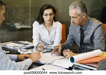 Clients discussing paperwork with businessman View Large Photo Image Picture - Clients discussing paperwork with businessman. Fotosearch
