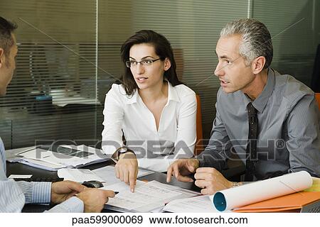 Clients discussing paperwork with businessman View Large Photo Image Stock Photo - Clients discussing paperwork with businessman. Fotosearch