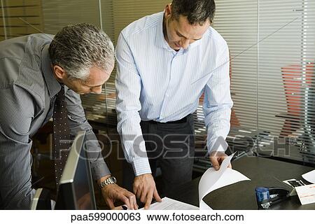 Colleagues discussing document in office View Large Photo Image Stock Image - Colleagues discussing document in office. Fotosearch