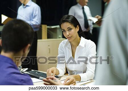 Colleagues discussing work in office at night View Large Photo Image Stock Image - Colleagues discussing work in office at night. Fotosearch