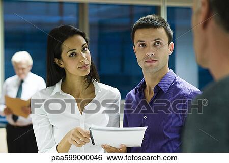 Colleagues discussing work in office View Large Photo Image Stock Photograph - Colleagues discussing work in office. Fotosearch
