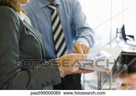 Colleagues discussing work in office, mid section View Large Photo Image Stock Photography - Colleagues discussing work in office, mid section. Fotosearch