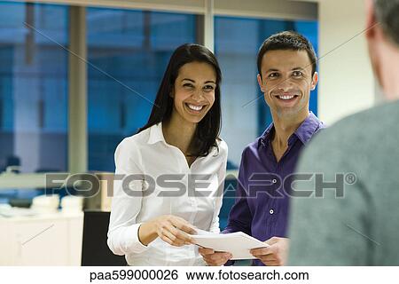 Colleagues laughing together in office View Large Photo Image Stock Photograph - Colleagues laughing together in office. Fotosearch