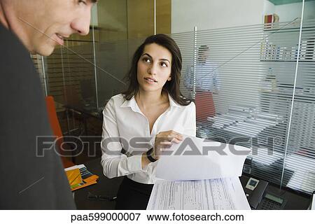 Executive reviewing document with colleague View Large Photo Image Stock Photo - Executive reviewing document with colleague. Fotosearch