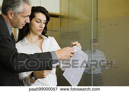 Executives reviewing document together View Large Photo Image Stock Photo - Executives reviewing document together. Fotosearch
