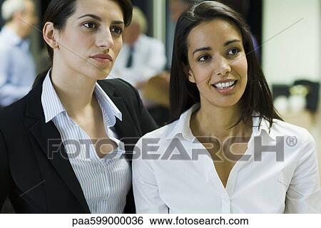 Female colleagues talking in office, portrait View Large Photo Image Stock Photograph - Female colleagues talking in office, portrait. Fotosearch