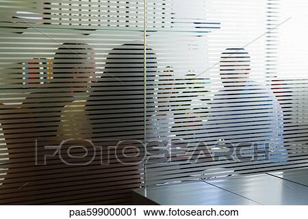 Meeting in office viewed through glass wall View Large Photo Image Stock Image - Meeting in office viewed through glass wall. Fotosearch
