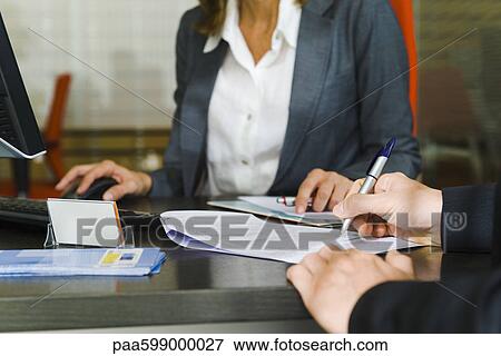 Stock Photo - Person signing paperwork, mid section. Fotosearch