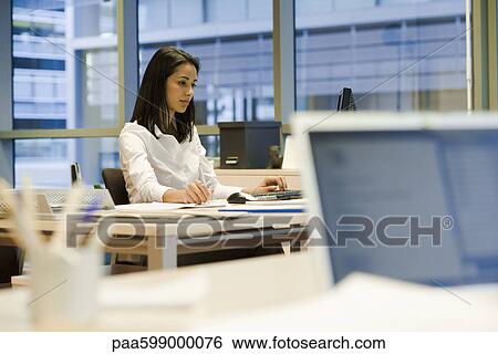 Woman working in office View Large Photo Image Stock Photograph - Woman working in office. Fotosearch