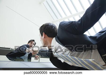 Businessman leaning over balcony, holding on to colleague's hand View Large Photo Image Stock Photography - Businessman leaning over balcony, holding on to colleague's hand. Fotosearch