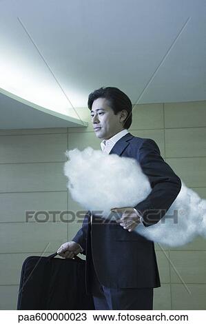 Stock Image - Businessman walking in corridor. Fotosearch