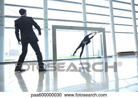 Stock Image - Businessmen playing soccer in lobby. Fotosearch