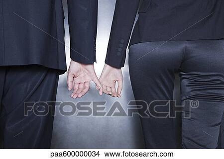 Picture - Professionals holding hands, cropped. Fotosearch