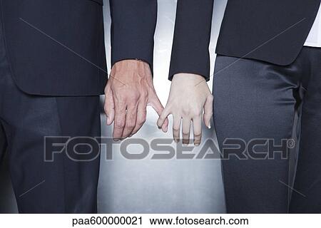 Professionals holding hands, cropped View Large Photo Image Stock Image - Professionals holding hands, cropped. Fotosearch