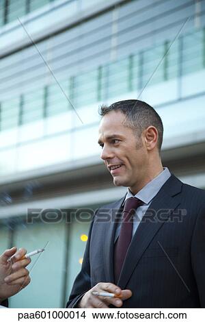 Businessman smoking outdoors View Large Photo Image Picture - Businessman smoking outdoors. Fotosearch