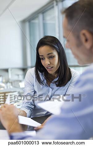 Businesswoman discussing work with colleague View Large Photo Image Stock Image - Businesswoman discussing work with colleague. Fotosearch