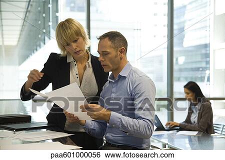 Colleagues discussing document View Large Photo Image Stock Photograph - Colleagues discussing document. Fotosearch