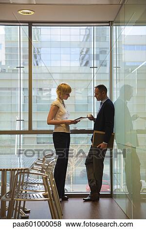 Colleagues discussing work over coffee View Large Photo Image Stock Photo - Colleagues discussing work over coffee. Fotosearch