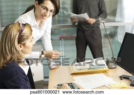Stock Image - Colleagues discussing work. Fotosearch