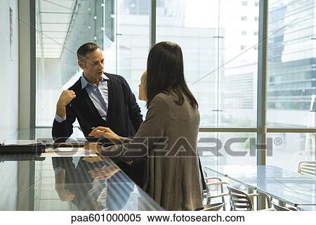 Colleagues discussing work View Large Photo Image Stock Photography - Colleagues discussing work. Fotosearch