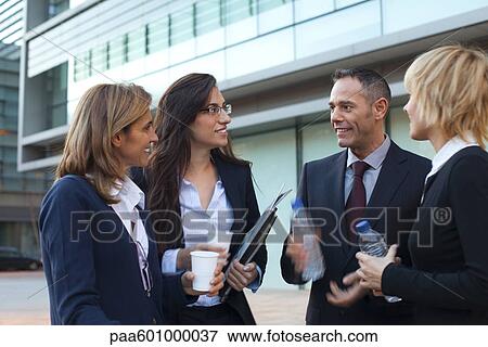 Stock Photo - Colleagues taking coffee break outdoors. Fotosearch