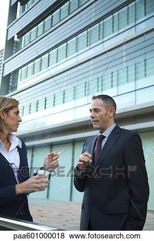 Colleagues taking smoke break outdoors View Large Photo Image Stock Photo - Colleagues taking smoke break outdoors. Fotosearch