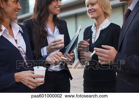 Colleagues taking smoking break outdoors View Large Photo Image Stock Image - Colleagues taking smoking break outdoors. Fotosearch
