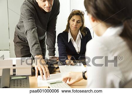 Colleagues working together in office View Large Photo Image Stock Photograph - Colleagues working together in office. Fotosearch