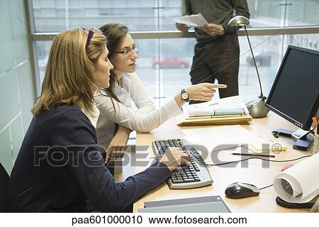 Colleagues working together on desktop computer View Large Photo Image Stock Image - Colleagues working together on desktop computer. Fotosearch
