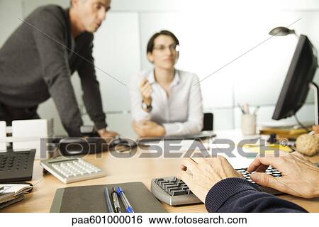 Working in office, cropped View Large Photo Image Stock Photograph - Working in office, cropped. Fotosearch