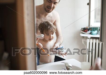 Father and toddler son brushing their teeth together View Large Photo Image Stock Photograph - Father and toddler son brushing their teeth together. Fotosearch