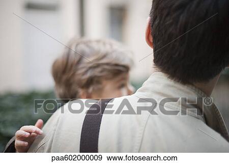 Stock Photo - Father carrying toddler son, over the shoulder view. Fotosearch
