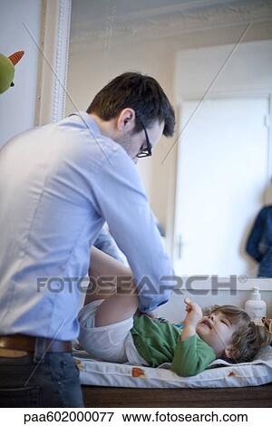 Stock Photo - Father changing son's diaper. Fotosearch