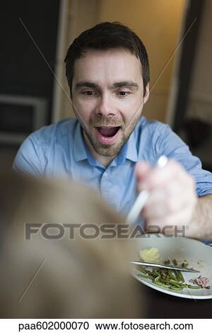 Stock Image - Father feeding young child, cropped. Fotosearch