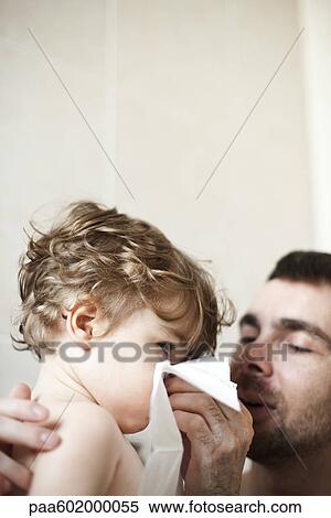 Stock Photography - Father helping toddler son blow his nose. Fotosearch