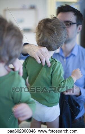 Father helping toddler son get dressed View Large Photo Image Stock Photograph - Father helping toddler son get dressed. Fotosearch