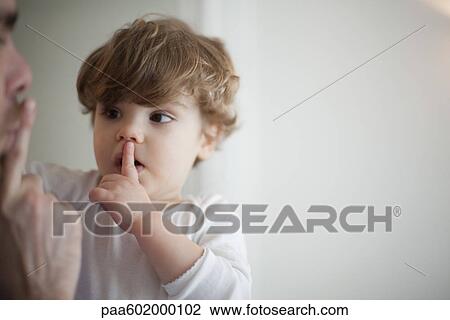 Stock Image - Father hushing toddler boy. Fotosearch
