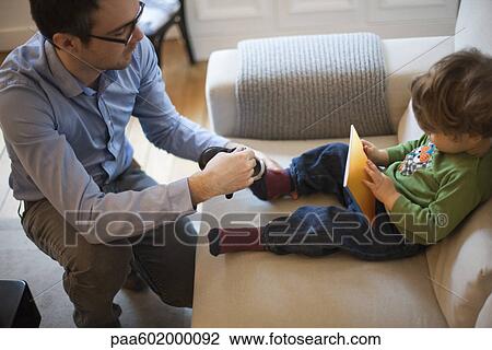 Father putting shoes on young son View Large Photo Image Stock Image - Father putting shoes on young son. Fotosearch