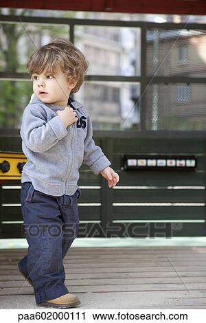 Stock Image - Little boy walking on playground. Fotosearch