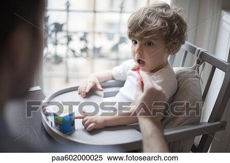 Stock Photography - Toddler boy being fed yogurt. Fotosearch