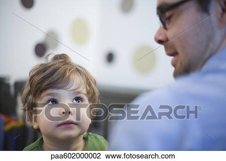 Toddler boy looking attentively at father View Large Photo Image Stock Image - Toddler boy looking attentively at father. Fotosearch